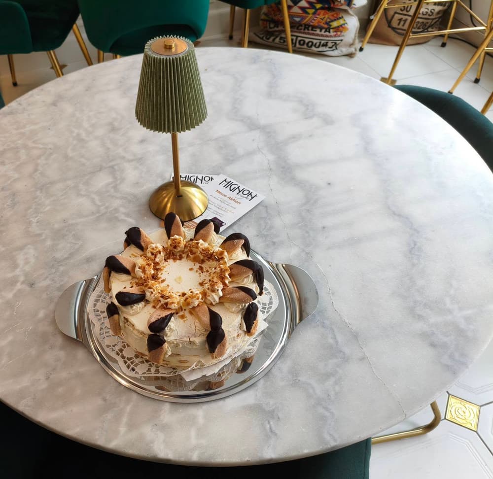 Cremetorte mit Biskotten auf dem Marmortisch im Café